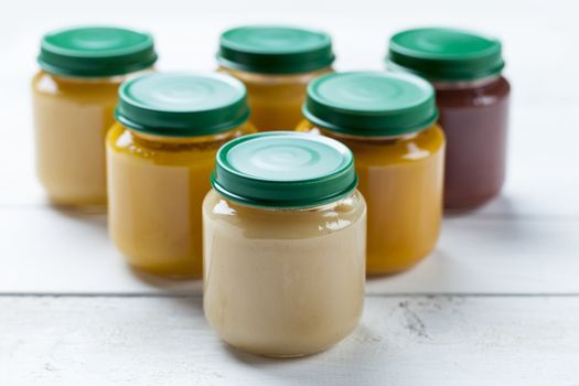 healthy ready-made baby food on a wooden table.