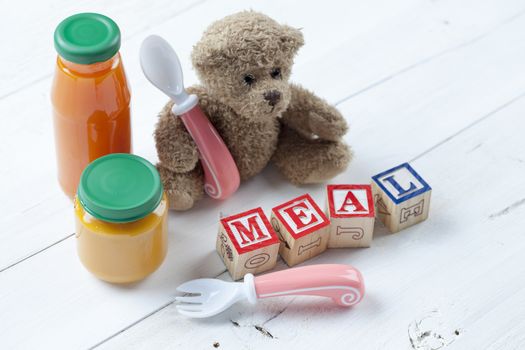 Teddy bear with jar of food on wooden table