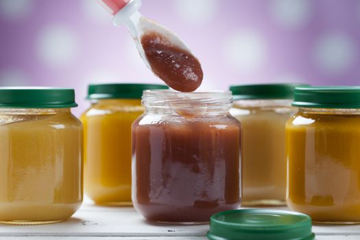 healthy ready-made baby food on a wooden table.