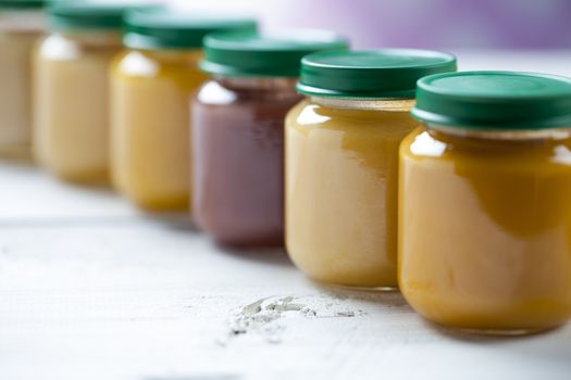 healthy ready-made baby food on a wooden table.