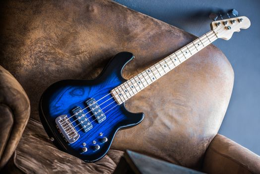 Bass Guitar Leaning Against a Couch. Blue Bass Guitar.