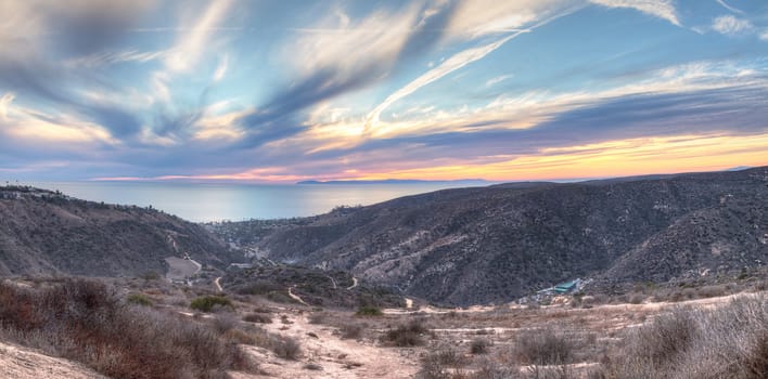 Laguna Canyon Road leading to the ocean from Top of the World hiking trail in Laguna Beach at sunset