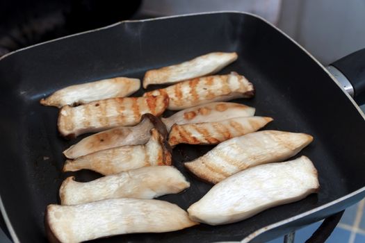 Cooking mushrooms and cheese on a grill pan. Pleurotus Eryngii (King Oyster Mushroom)