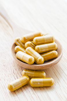 Alternative medicine tablets on a wooden spoon.