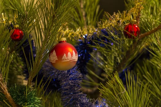 beautiful red christmas balls and garland on christmas tree