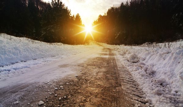 Snow covered winter road with shining streetlights in rural areas