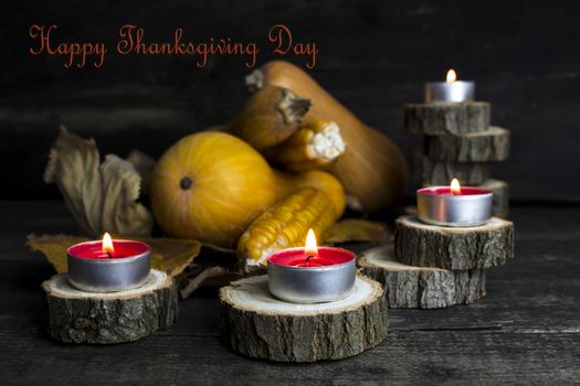 Happy Thanksgiving Day, Decoration on a wooden table with Burning Candles and  Pumpkins, Corncob, autumn leaves in the background