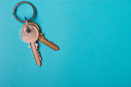silver house key lying on blue paper background