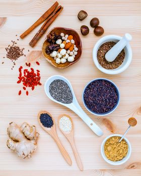 Nutritious Foods and Super foods selection with supplement powders in mortar and spoons setup on wooden background. Chia seeds ,flex seeds ,ginger ,rice berry ,sesame lotus seeds and mixed nuts.