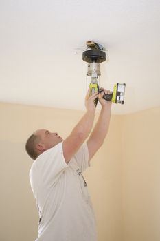 Electrician installing new light fixture and fan 