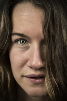 Close up portrait of woman looking straight, isolated on black background.