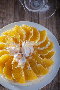 Cheesecake decorated with oranges and physalis on wooden table