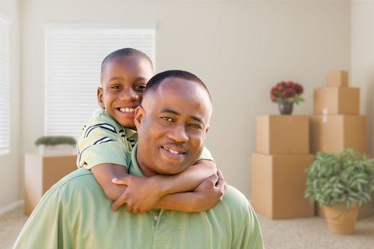 Happy African American Father and Son In Room with Packed Moving Boxes.