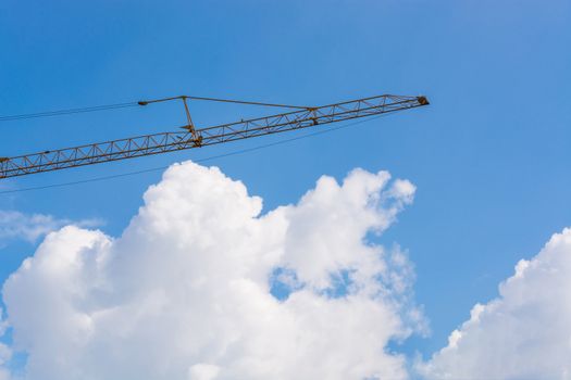 Construction machinery at a construction site in the background a blue sky.