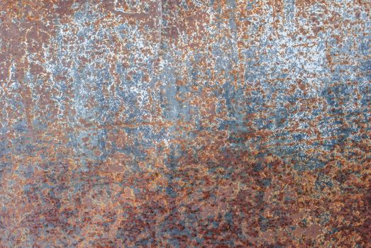 rusty iron surface covered with old chipped paint, which has long been influenced by different climatic conditions