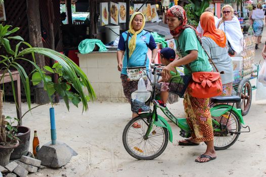 a portrait of happy muslim woman enjoy riding bicycle outdoor on the walking road