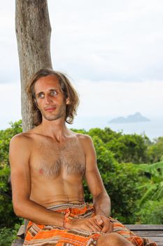 a young man sitting in yoga lotus pose meditation outdoors. Phi Phi Don Island, Thailand