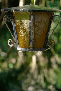 a vintage style street light with crown on the top. Beautiful historical retro metal Streetlight on green tree background.