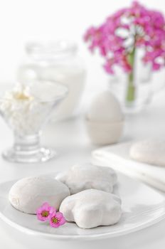 Gingerbread, eggs, curd and milk for Breakfast. White background, high key, selective focus. Pink flowers