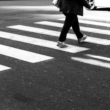 Men walking on zebra crossing street.