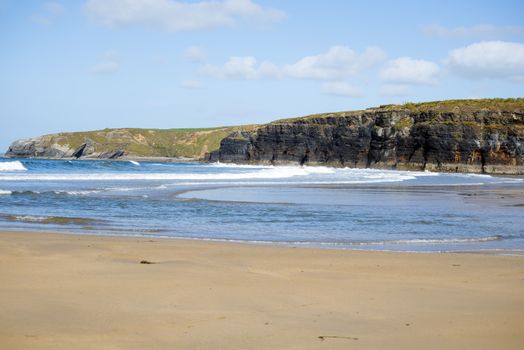 bright winter view of kayaker at ballybunion beach and cliffs on the wild atlantic way in ireland