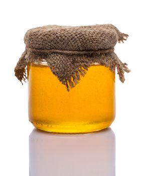 glass jar of honey on white background