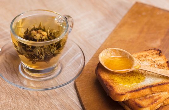 tea and toast with honey on wooden background