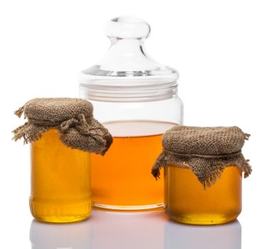 glass jars of honey on white background