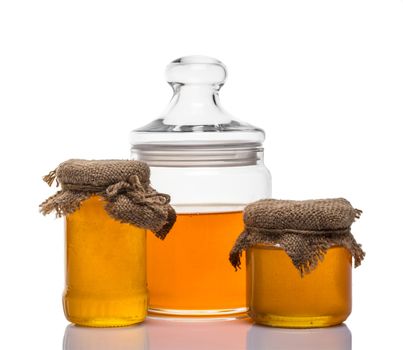 glass jars of honey on white background