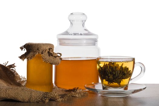 cup of green tea and honey in jars