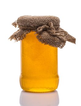 glass jar of honey on white background