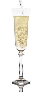 is poured into a glass champagne on white background