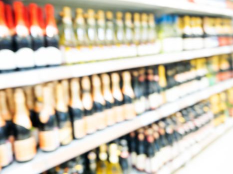 Abstract blurred supermarket colorful shelves with alcohol, champagne, wine bottles as background