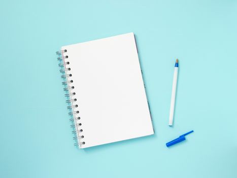 Top view of blank note paper with pen on blue wood table for background