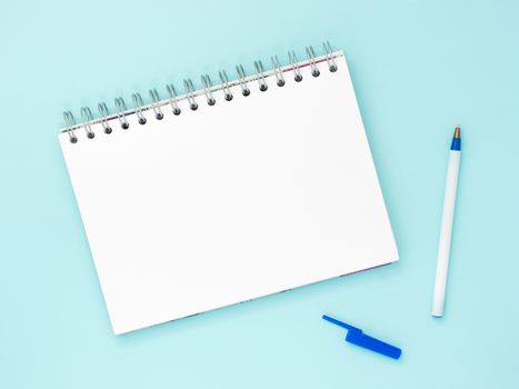 Top view of blank note paper with pen on blue wood table for background