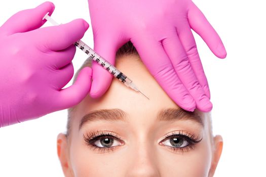 Beautiful face frown wrinkles filler collagen  injection on forehead Cosmetic skincare spa beauty treatment with pink gloves by eye, on white.