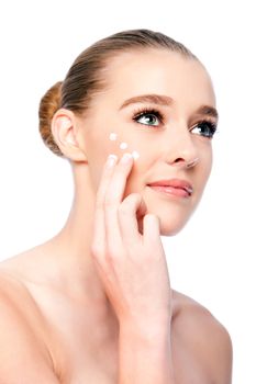 Beautiful woman applying Moisturizing facial skincare treatment cream.