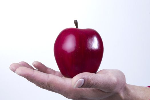 Arm and hand holing an apple isolated on white