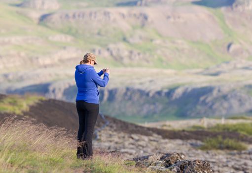 Shot of a young woman looking at the landscape while hiking in Iceland