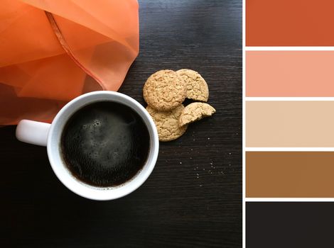 Cup with hot coffee on wooden table and palette of colors