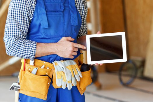 Construction worker pointing at digital tablet close-up