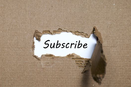 The word subscribe appearing behind torn paper