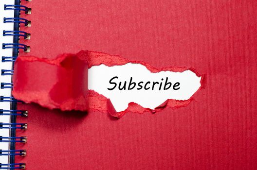 The word subscribe appearing behind torn paper