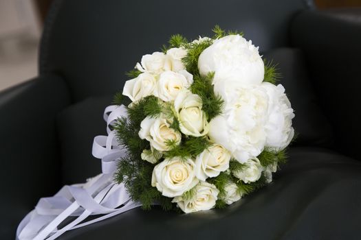 Close up view of a bridal bouquet put an armchair in a living room