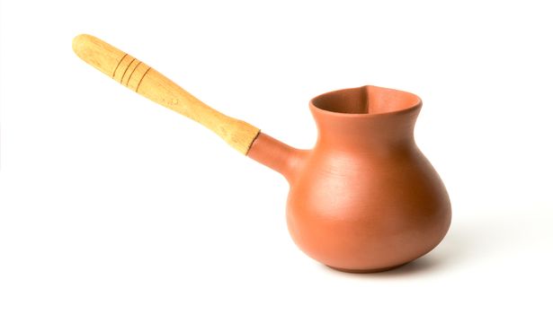 Brown ceramic turk for coffee with a wooden handle on a white background