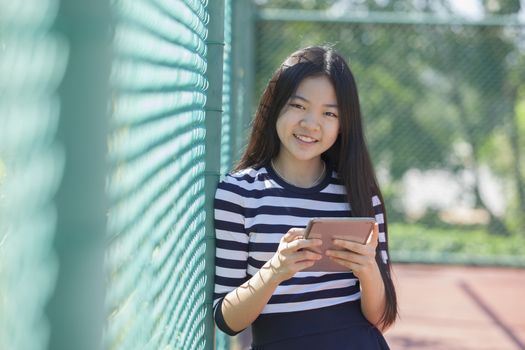 asian girl and computer tablet in hand standing with toothy smiling face