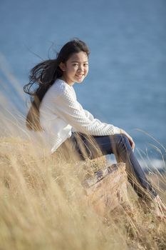 portrait of asian teenager relaxing on natural field