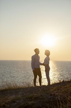 silhouette photography of couples younger man and woman standing against sun set sky