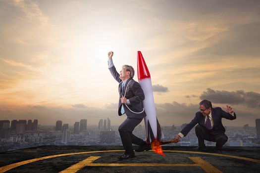 two business man playing rocket toy on high building roof with sky scraper background abstract for successful business partner