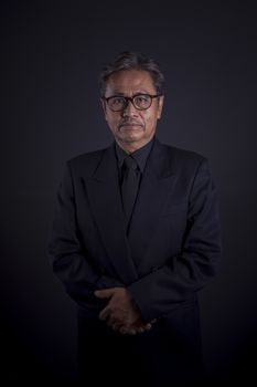 senior thai man in black suit